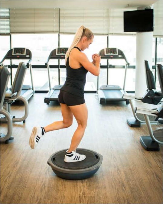 Single leg balance on a bosu ball with the knee slightly bent