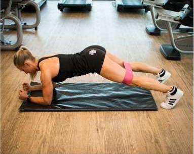 Forearm plank with a resistance band around the knees