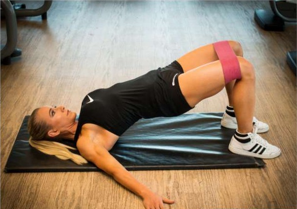 Glute thruster with a resistance band above the knees