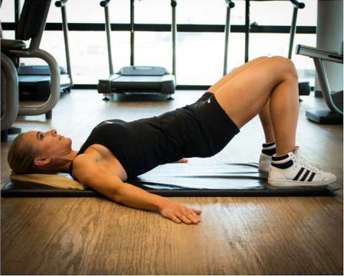 Holding a bridge with hands on hips for hip tilts