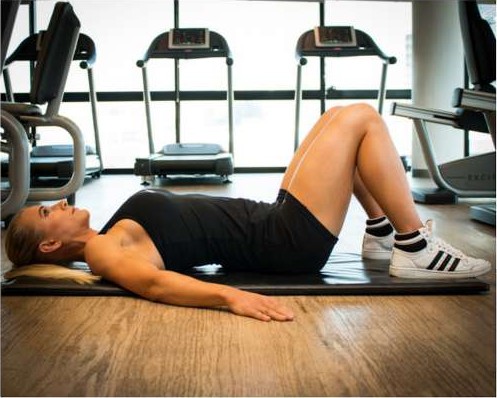 Woman lying on a mat in neutral spine position before a pelvic tilt