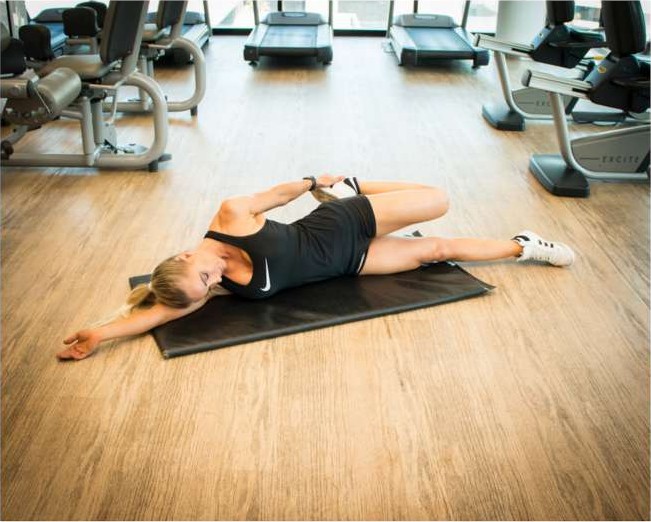 Side lying quad stretch pulling the heel towards the glute
