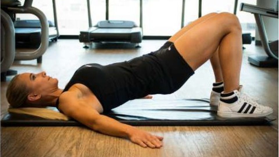 Holding a bridge with hands on hips for hip tilts